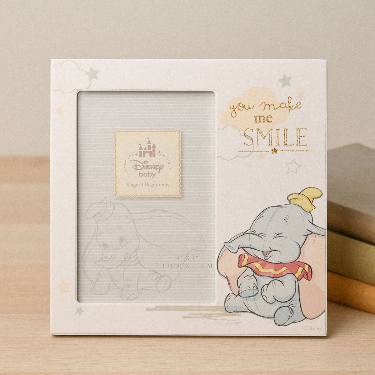 White square photo frame for a 6 x 4in photo, featuring a smiling Dumbo illustration with "you make me SMILE" in gold text amid clouds and stars.