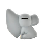 Sitting Dumbo Elephant resin money box in matt grey, shown from the side with one large ear swept forward and a coin slot on top of the head, against a plain white background.
