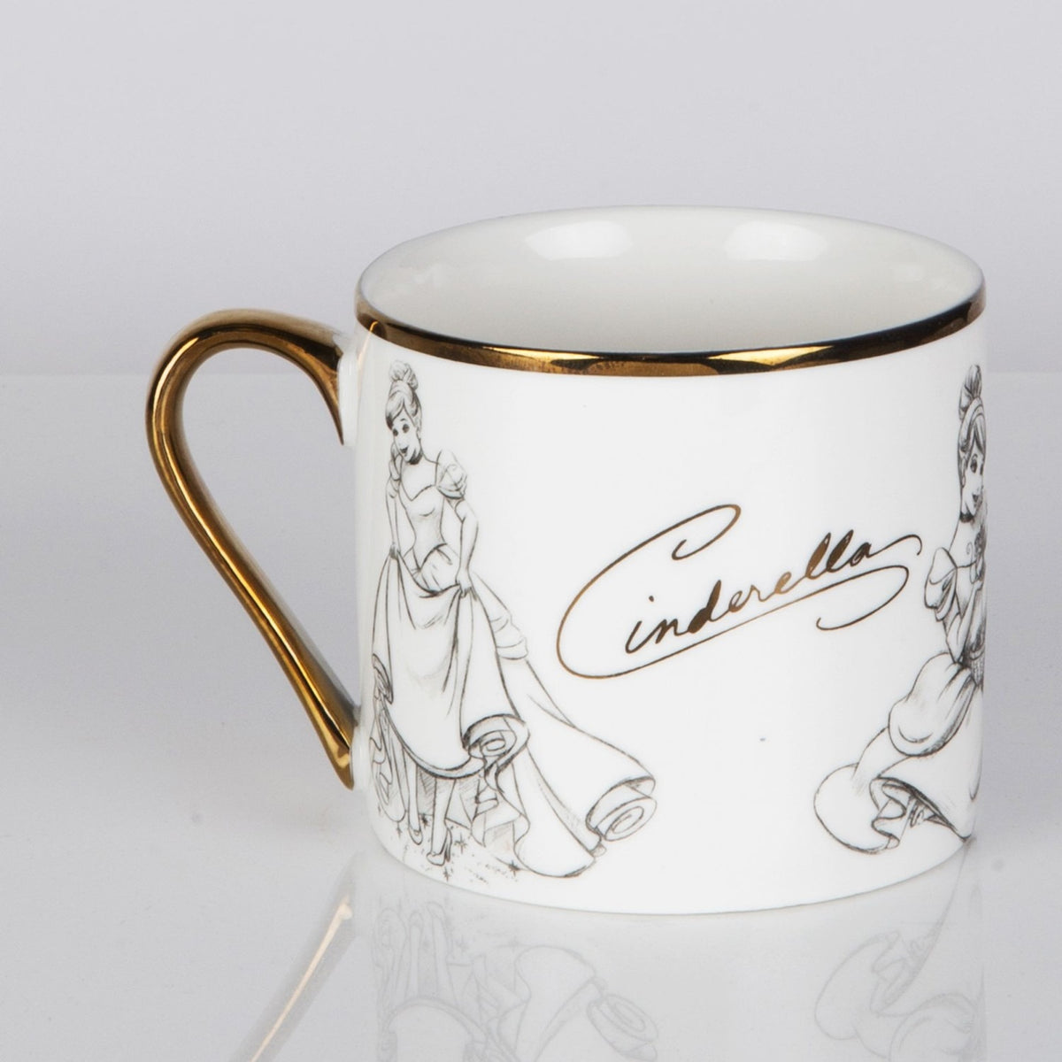 White porcelain Cinderella Sketch Classic Collectable mug with gold handle and rim, grey pencil-style sketches of Cinderella, and gold "Cinderella" script, on a plain background.