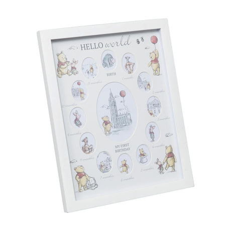 Cream MDF multi-aperture photo frame with twelve oval openings around a central oval, labelled Hello World and My First Birthday with Winnie the Pooh illustrations.