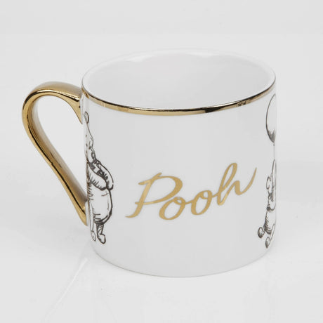 White porcelain Pooh mug with gold rim and handle, featuring black sketch-style Pooh illustrations and "Pooh" in gold script, on a plain white background.