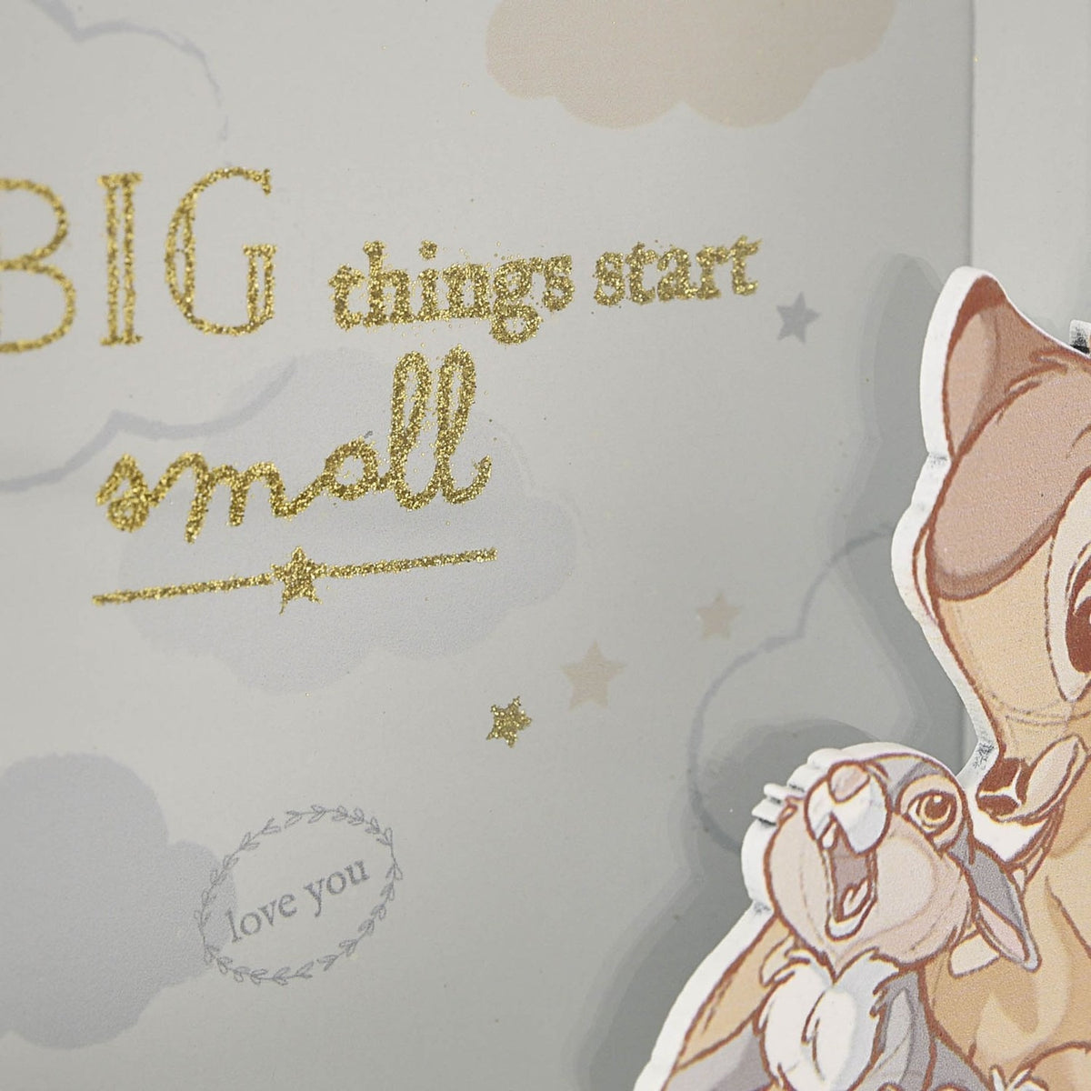 Close-up of the square white money box with raised cut-out Bambi and rabbit, gold glitter "BIG things start small" text and a "love you" leafy ring on a pale grey cloud print.