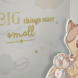 Close-up of the square white money box with raised cut-out Bambi and rabbit, gold glitter "BIG things start small" text and a "love you" leafy ring on a pale grey cloud print.