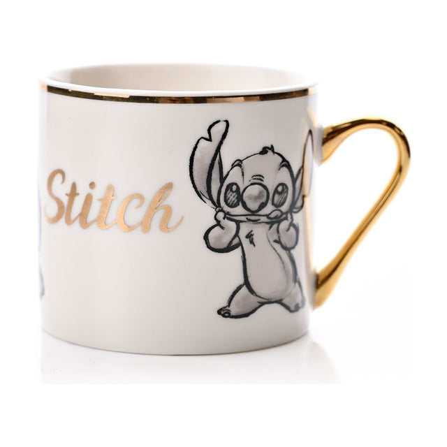 White porcelain Stitch mug with grey pencil-style sketch, gold "Stitch" script, gold rim band, and gold handle, shown on a plain white background.