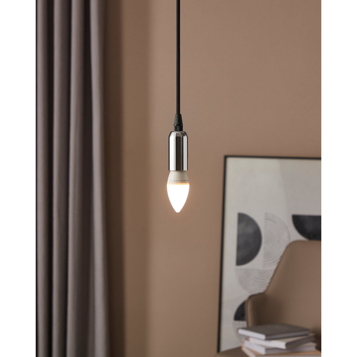 Pendant light fitted with a Dimmable LED Bulb E14 5.5W, candle-shaped opal shade glowing warm white, hung on black cable against a muted pink wall near a curtain and framed artwork.