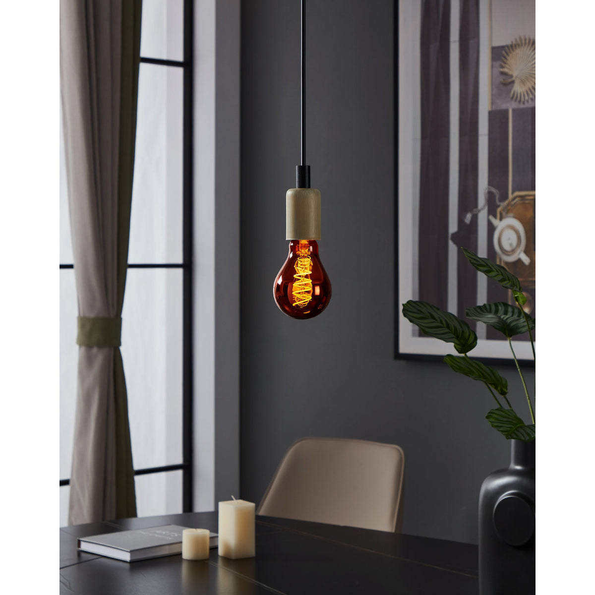 Dimmable LED filament bulb E27 in copper-toned glass with spiral filament, glowing warm white in a pendant fitting above a dark dining table.