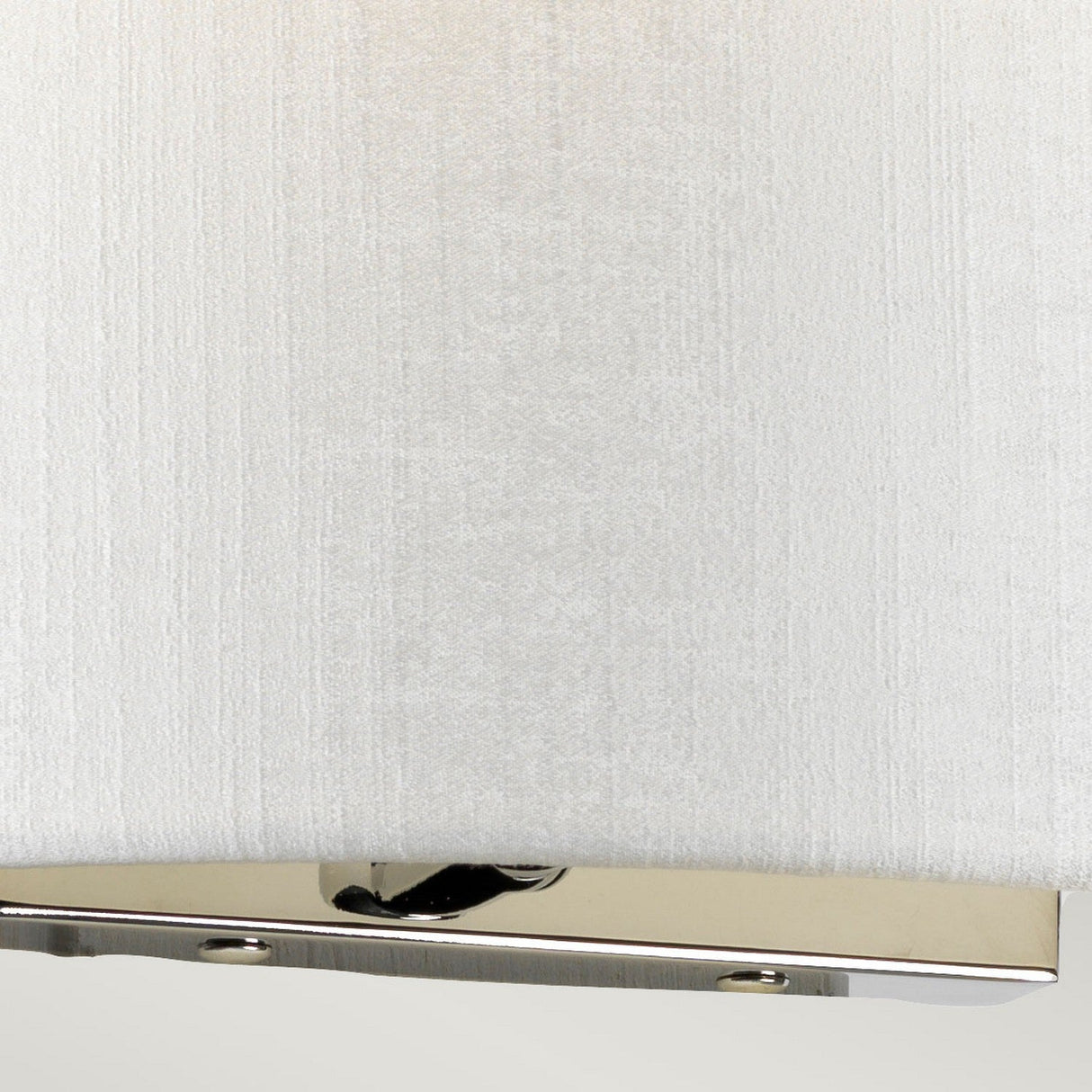 The Cooper Medium Curved Wall Light - Polished Chrome features a close-up view of its white fabric lampshade and polished chrome rectangular base with a visible switch, set against a plain background. Ideal for contemporary interiors, it seamlessly combines elegance with functionality.