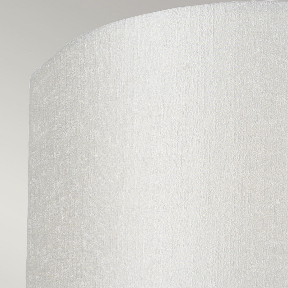 A close-up image of a textured, curved white surface featuring subtle vertical lines, reminiscent of the modern minimalist design seen in the Cooper Small Curved Wall Light - Aged Brass, is set against a light gray background. The scene evokes a warm glow similar to ambient lighting from its aged brass finish.