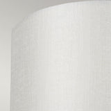 A close-up image of a textured, curved white surface featuring subtle vertical lines, reminiscent of the modern minimalist design seen in the Cooper Small Curved Wall Light - Aged Brass, is set against a light gray background. The scene evokes a warm glow similar to ambient lighting from its aged brass finish.
