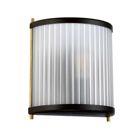 The Corona Wall Light - Dark Brown is a contemporary wall lamp with a cylindrical design, offering ambient lighting through its ribbed, frosted glass front. It features a matte black border and brass accents on the sides and is intended for indoor use.