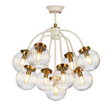 The Cosmos 9 Light Pendant combines a cream-painted metal structure with aged brass accents, showcasing a modern design. Its nine curved arms extend into hand-blown glass shades, each housing a glowing bulb, creating an elegant and stylish lighting fixture.