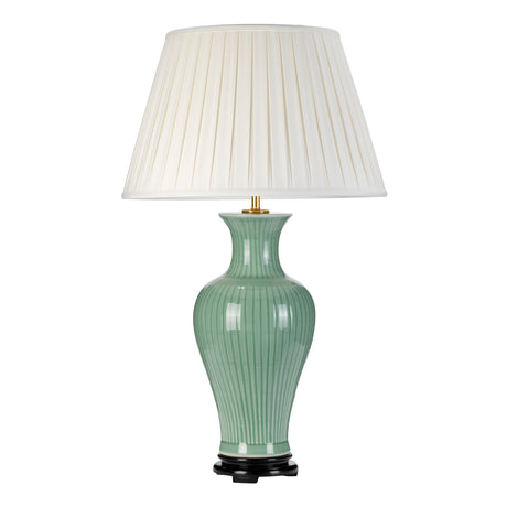 The Dalian Table Lamp with Tall Empire Shade - Celadon features a decorative ribbed green ceramic base, a pleated white empire shade, and is set on a black circular stand with a brass finial, evoking the elegance of an oriental ceramic vase.