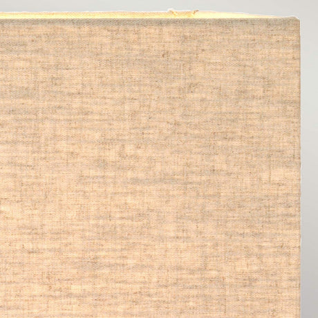 Close-up of the edge of a textured, light brown hardcover book with a well-worn spine and slightly frayed cover, evoking the sense of frequent use and antiquity similar to the Dorado Table Lamp with Rectangle Shade in Bronze Patina against a soft gray background.