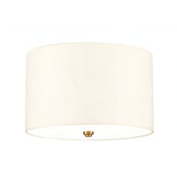 The Fletcher 14" Flush features a clean cylindrical design with an ivory faux silk shade and a small, round fixture finished in aged brass at the bottom center. The light is off, displayed against a white background which subtly highlights its flush mount design.
