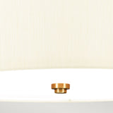 A close-up view from below showcases the Fletcher 18" Flush Ceiling Fixture, featuring an ivory shade and a central aged brass knob. The fabric's texture and the sleek metallic finish of the knob are beautifully highlighted.