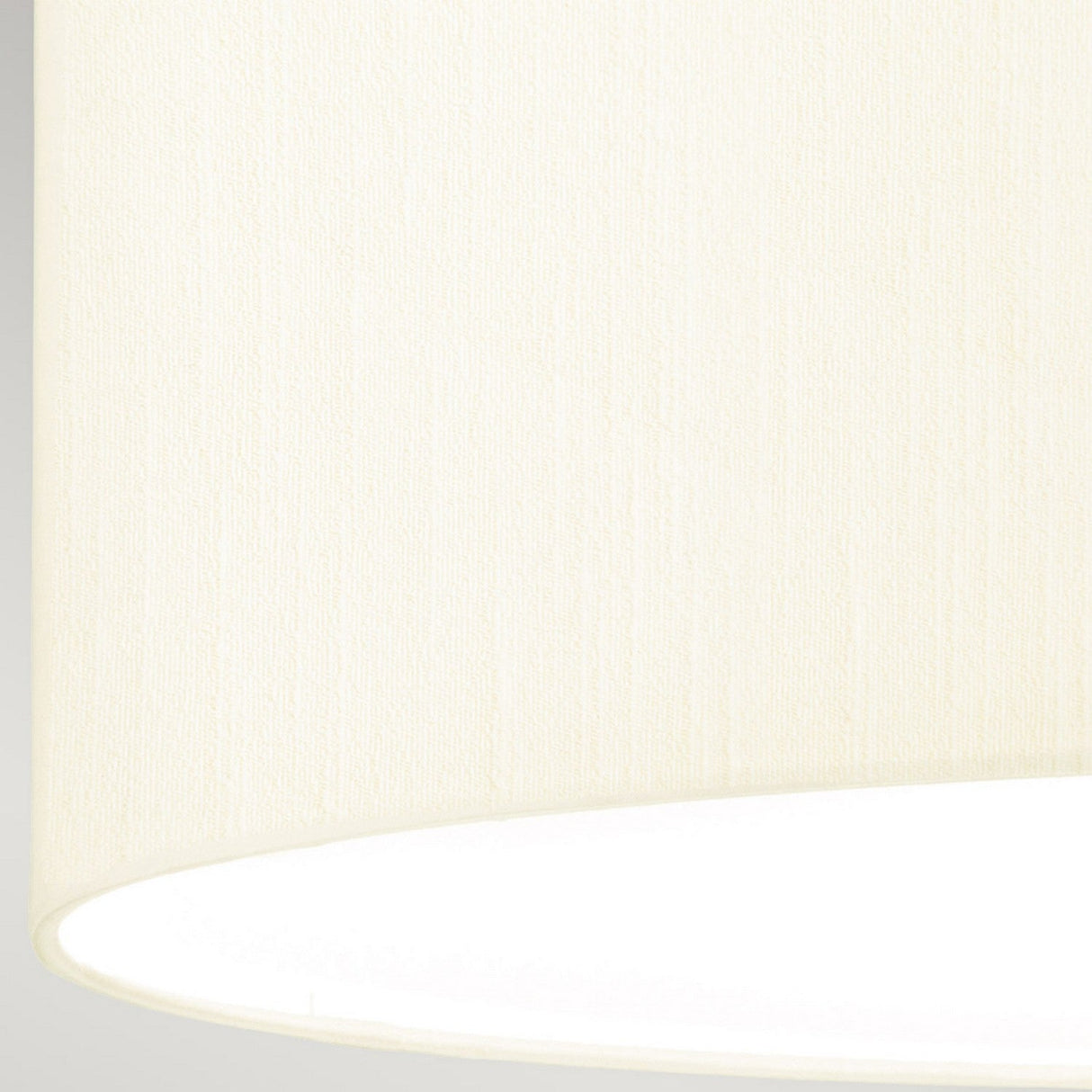 Close-up of an ivory textured lampshade from the Fletcher 18" Flush in a polished chrome finish, set in a contemporary interior. The fabric has a smooth appearance with subtle vertical lines, while the bright white interior reflects light. The image focuses on the lower portion of the lampshade against a pale background, complementing the Fletcher Flush Ceiling Fixture.