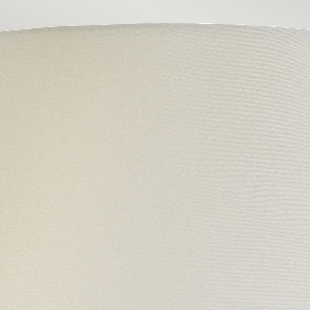 Close-up view of a simple, light beige lampshade with a textured surface. The top edge is smoothly rounded, forming a gentle arc against a plain white background, reminiscent of the elegant design found in the Harbin Gourd Table Lamp With Tall Empire Shade in Duck Egg Blue.