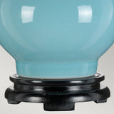 Close-up of a Duck Egg Blue ceramic vase with a glossy finish, mounted on a black wooden base. Its smooth, rounded shape mirrors the elegance of the Harbin Gourd Table Lamp With Tall Empire Shade in Duck Egg Blue. The neutral background beautifully accentuates the vase's color and texture.