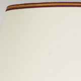 Close-up of a Tall Empire shade with a smooth cream surface and a trim featuring brown, orange, and yellow stripes along the top edge, perfectly complementing the Majin Table Lamp With Tall Empire Shade - Oxblood.