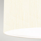 Close-up of the Pearce 18" Pendant Light's ivory lampshade, featuring a textured fabric surface that epitomizes modern design. The image highlights the bottom right portion of the polished chrome fixture, showcasing its rounded edge against a light gray background.
