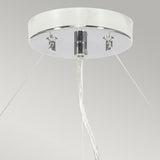 Close-up view of the Pearce 26" Pendant Light featuring a polished chrome finish and an ivory shade. Three clear wires extend from the round white base, complementing the sleek aesthetic of modern interiors. The background is a plain light gray, highlighting the fixture's elegant design.