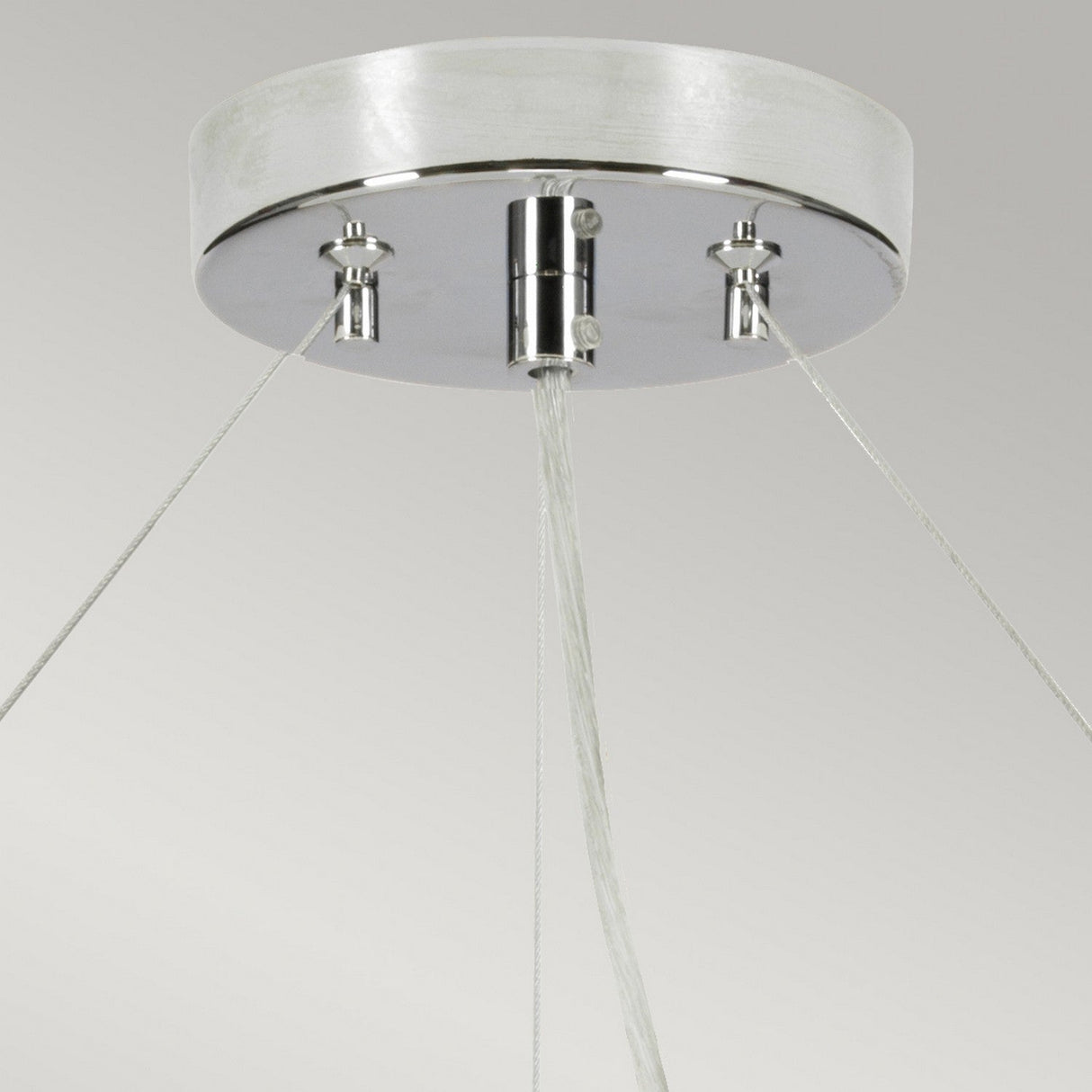 Close-up of the Pearce 30" Pendant Light - Polished Chrome, Ivory Shade, showcasing a modern lighting design with a round metallic base in polished chrome. Sleek cables elegantly extend from the base, supporting the structure against a neutral background.