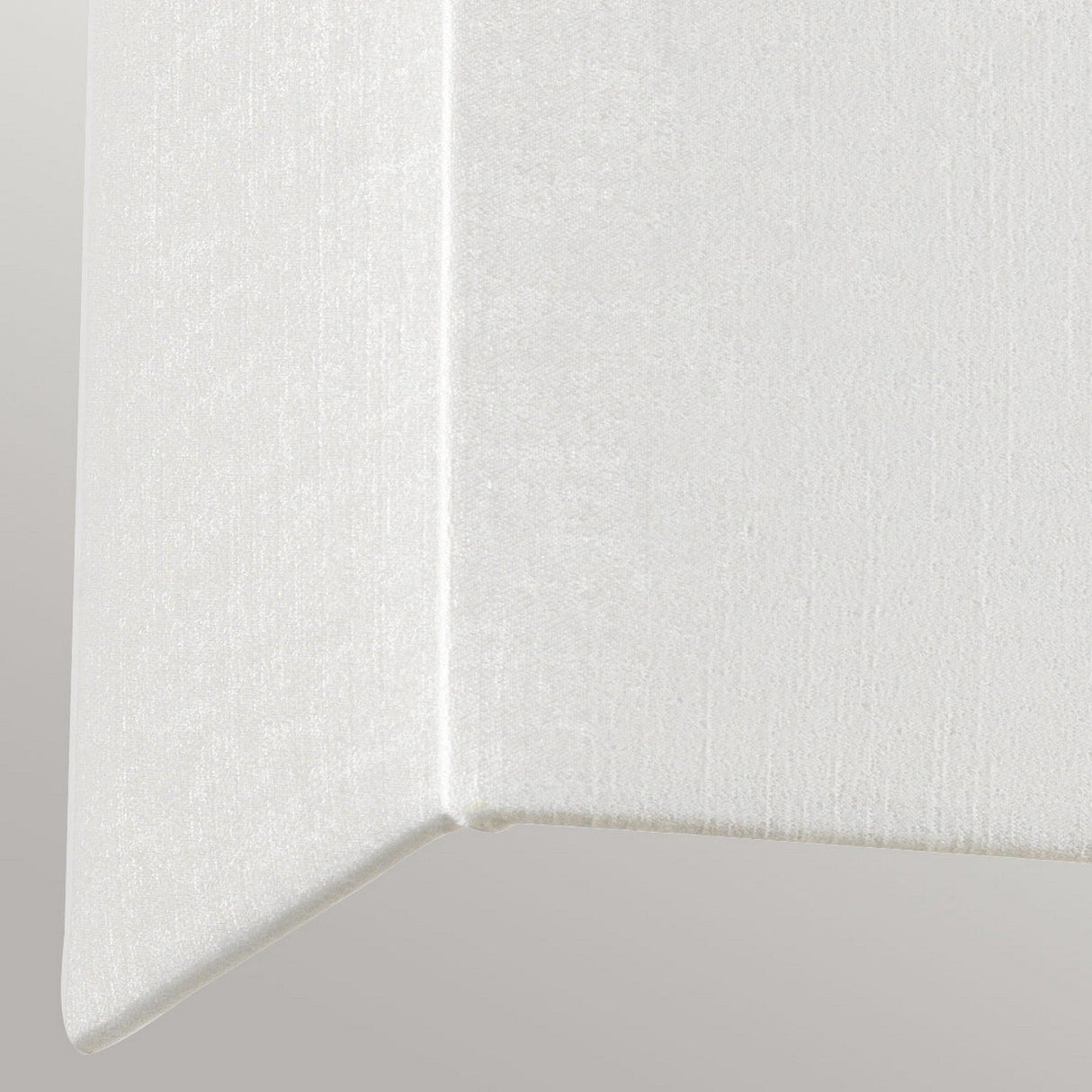 Close-up of a white, textured geometric shape with a right angle corner against a light gray background, reminiscent of the Riley Large Rectangular Wall Light in polished chrome. The surface appears smooth and slightly reflective, adding a touch of contemporary design elegance.