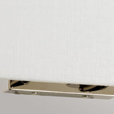 A close-up of the corner of the Riley Large Rectangular Wall Light in polished chrome against a textured white background showcases its shiny metal surface. The reflected light forms a subtle pattern, capturing the essence of contemporary design lighting.