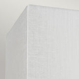 Close-up image of the Riley Small Rectangular Wall Light - Aged Brass, showcasing its soft, textured white corner against a light gray background. The fabric exhibit features a subtle vertical pattern reminiscent of faux silk shade, complementing its sophisticated aged brass finish.