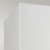 Close-up view of the corner of a textured white mattress set against a light gray background, subtly illuminated by the Riley Small Rectangular Wall Light in Polished Chrome, which casts gentle shadows.