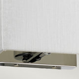 A close-up of the Riley Small Rectangular Wall Light - Polished Chrome showcases its contemporary lighting design, featuring a white fabric shade and a polished chrome base that exudes modern elegance.