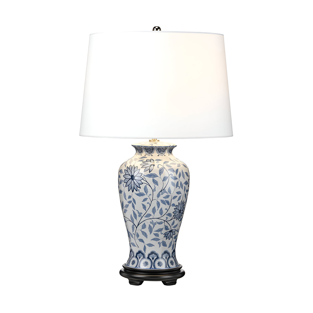 The Ying 1 Light Table Lamp - Blue & White showcases a decorative design with a white ceramic base adorned with intricate blue floral patterns inspired by classic Chinese motifs. A wide, white fabric shade provides ambient lighting, and the lamp is set on a dark, rounded stand.