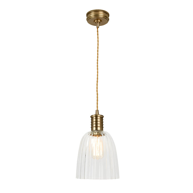 The Douille 1 Light Pendant in aged brass features a gracefully suspended design with a twisted cord. Its clear ribbed glass shade reveals an exposed bulb, beautifully complemented by LED filament lamps, creating an elegant and timeless look.