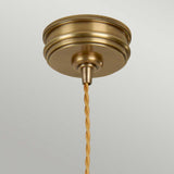 The Douille 1 Light Pendant in aged brass showcases a twisted braided cord, elegantly suspended against a plain background.
