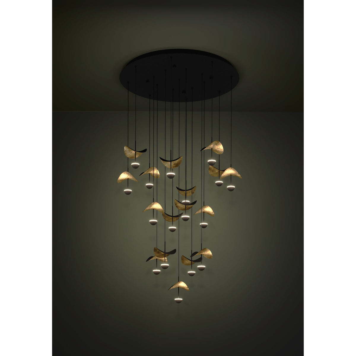 Dracera 17 Light Pendant in black, a round ceiling canopy with cascading cords holding curved leaf-like shades in gold and black over small warm-white LED domes, staggered at varying heights.