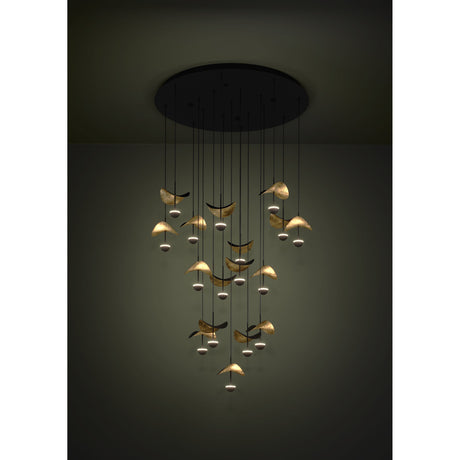 Dracera 17 Light Pendant in black, a round ceiling canopy with cascading cords holding curved leaf-like shades in gold and black over small warm-white LED domes, staggered at varying heights.
