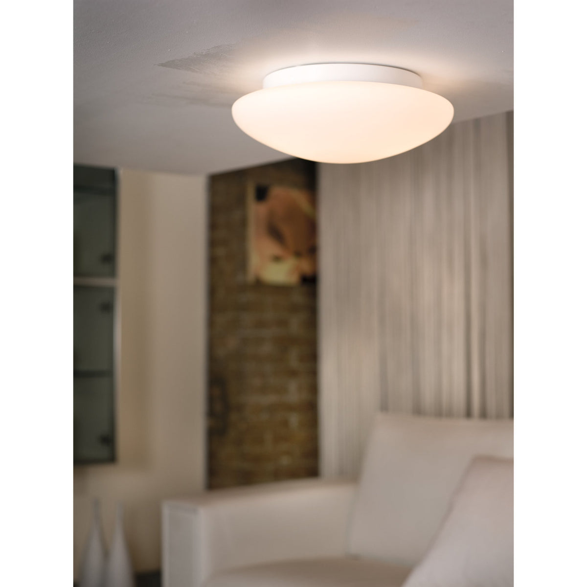 Drasmena Flush Ceiling Light 20cm in white, with domed opal glass shade and white steel base, shown illuminated on a ceiling in a living room setting.