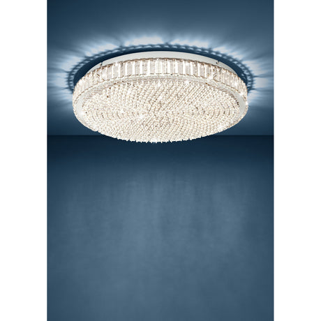 Drasvessa LED Flush Ceiling Light 60.5cm in chrome, round fixture with crystal edge band and beaded crystal face, shown illuminated against a dark blue wall and ceiling.