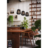 Drilmine Paper Linear Pendant Light in black, three tapered woven shades on a slim steel bar, shown above a wooden dining table in a living room setting.