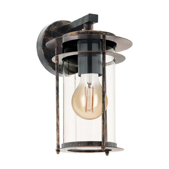 Antique copper lantern-style outdoor wall light with square arm, clear glass cylinder caged by vertical rods, and visible E27 bulb, shown on a white background.