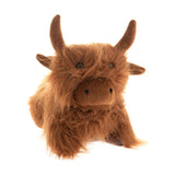 Shaggy Highland Cow Door Stop in brown, modelled lying down with raised horns, a long shaggy coat, small dark eyes peeping through the fringe and a smooth muzzle, shown on a plain white background.