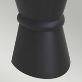 A close-up of the Dungarvan 2 Light Outdoor Up & Down Wall Light in black, featuring a textured cylindrical shape with a flared end and an elegant ring-like detail near the top. Highlighting its UV resistance, it sits on a light grey surface, showcasing its ideal suitability for outdoor lighting applications with its corrosion-proof design.