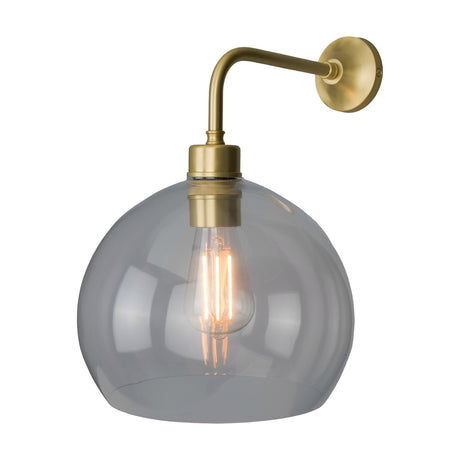 Eden Glass Globe Wall Light with a clear open-bottom glass shade on a brass swan-neck arm and round wall plate, shown with visible bulb on a plain white background.