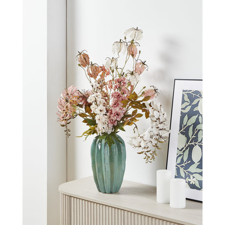 Egele Ceramic Vase in light green with a ribbed, wavy-rimmed body, holding a pink and white floral display on a console table beside framed art.