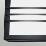 Close-up of the Egil-2 Outdoor Wall/Ceiling Light in graphite, featuring a minimalist design with horizontal metal slats, crafted from cast aluminum. Mounted against a light gray wall, this fixture highlights sleek lines and emits a soft, diffused white light.