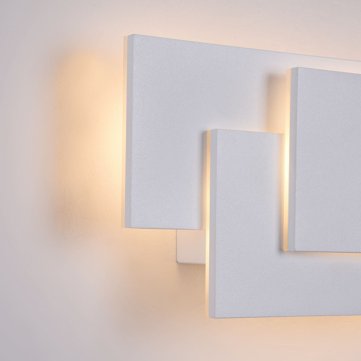 Close-up of the white Trame LED wall light, showcasing smooth finish and quality build.