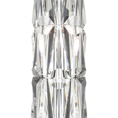A close-up of the Puntes Floor Lamp reveals its faceted clear crystal design with geometric shapes and reflective surfaces. Light refracts to create prismatic effects, while its symmetrical design and central metallic connector exude modern elegance.