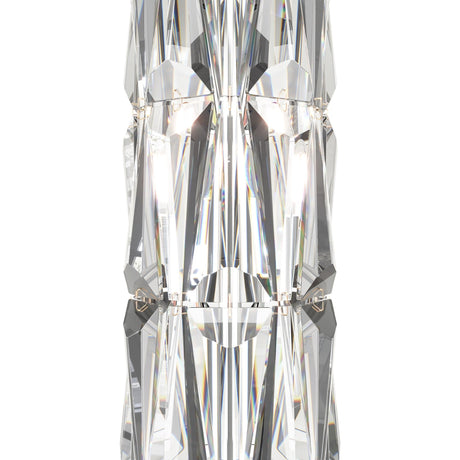 A close-up of the Puntes Table Lamp - Gold With Crystal reveals intricately faceted glass that reflects light, creating a symmetrical, kaleidoscopic effect. This luxurious lamp elegantly complements the vertically aligned crystal accents in the image.