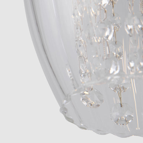 The Blues 3 Light Bar Pendant in nickel features clear glass that reflects light beautifully, with shimmering crystal accents. The plain, neutral backdrop highlights the intricate design details of this stylish chandelier.