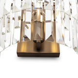 The Revero Classic Wall Light features elongated rectangular transparent glass prisms vertically arranged on a polished brass fixture, casting a sparkling effect against a white background.